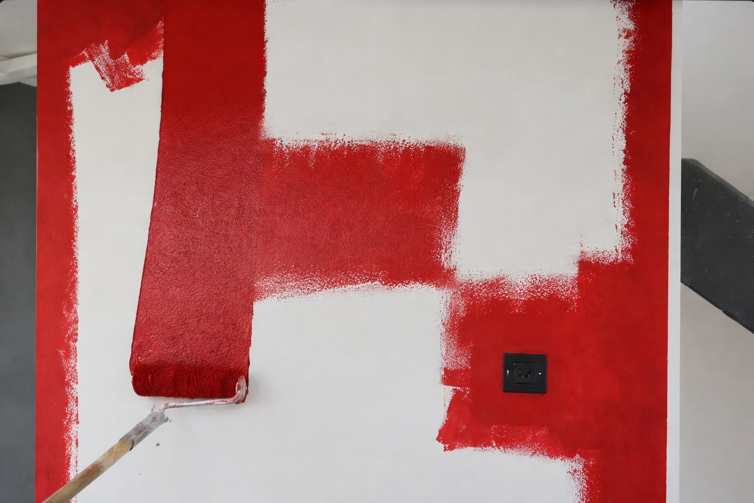 Zid u procesu farbanja u tamnu crvenu boju pomoću valjka